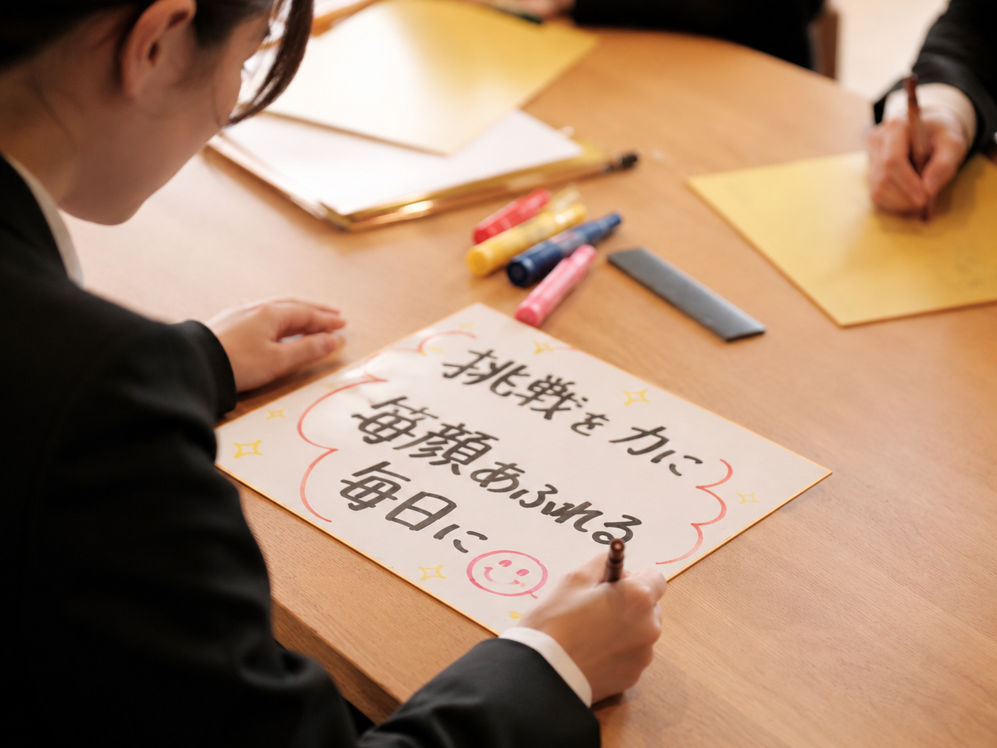 入社式で色紙に目標を書く新入社員